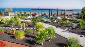 A resort with a pool, outdoor seating, and a view of the ocean. - Hotel Lava Beach (Tías)
