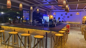 A bar area with stools, hanging lights, and a counter with bar tools. - Mali Beach Apart Otel (Seferihisar)