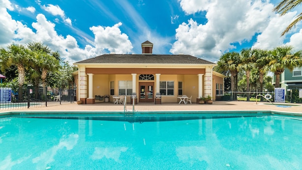 A swimming pool with a covered area and palm trees. - Coral Cay Resort #2 - 4 Bed 3 Baths Townhome (Kissimmee)