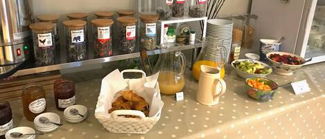 Un bufé de desayuno con diversas opciones de comida y acompañamientos.