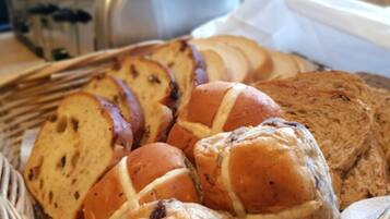 A basket of sliced bread with a rustic appearance, possibly a whole grain or artisan variety, placed on a table.