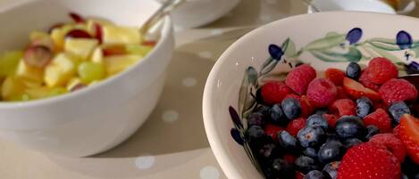 A table with three bowls of fruit.