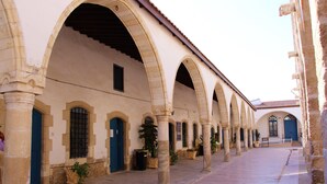 A corridor with arches, columns, and blue doors. - Tzionis Petroktisto Holiday Stonehouse (Lympia)