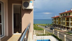 Un balcon avec une piscine, une vue sur la mer et un immeuble doté de balcons.