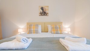 A double bed with two pillows, a headboard, and two bedside lamps. - Hamilton Grace - The Quadrant (Swindon)