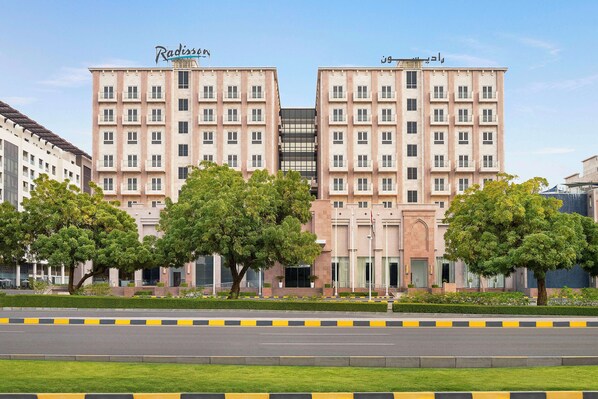 A modern hotel with a symmetrical facade, multiple floors, and a central entrance.