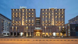 Un hotel grande y moderno con una entrada destacada y varios pisos.