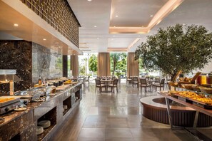A buffet area with marble countertops, multiple food stations, and seating arrangements.