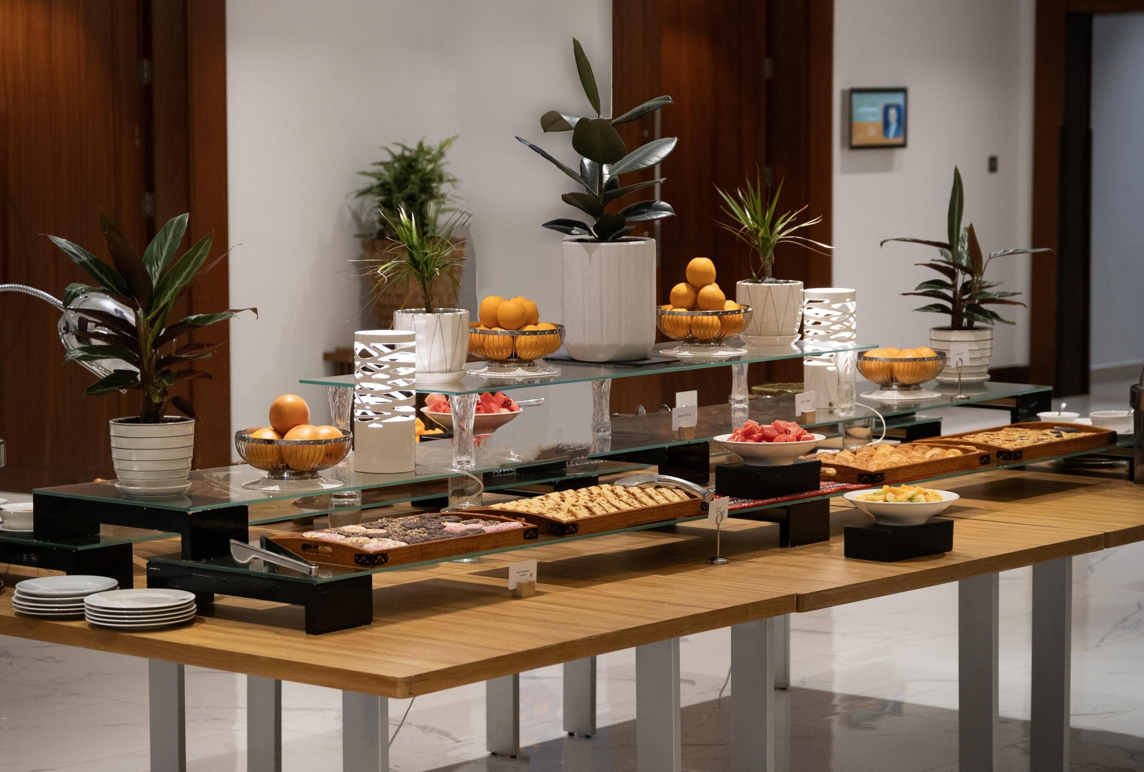 Un buffet proposant une variété de plats, de verrerie et de plantes en pot.