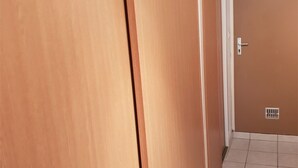 Un pasillo con puertas de madera y suelo de baldosas.