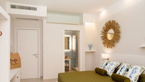 Un dormitorio con cama, almohadas, un espejo y una puerta.