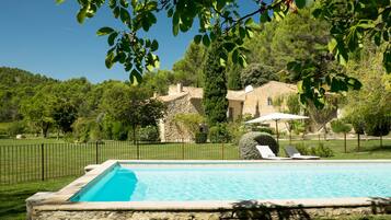 Een seizoensgebonden buitenzwembad en parasols bij het zwembad