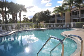 A swimming pool with a white fence, lounge chairs, and palm trees. - Sun Lake #3 - 3 Bed 3 Baths Condo (Kissimmee)