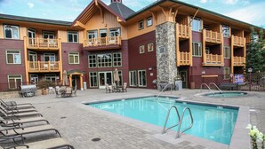 A hotel with a pool area, outdoor seating, and a stone facade. - Sunstone 208 Updated Ski-In Ski-Out Condo At Sunstone Lodge with Great Complex Amenities by RedAwning (Mammoth Lakes)