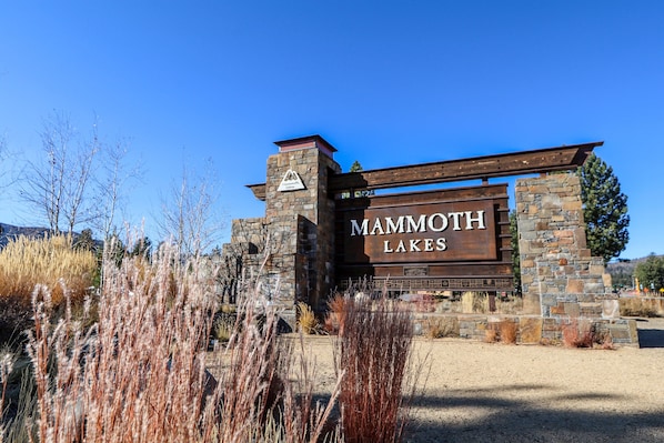 A sign for Mammoth Lakes with a stone and wood structure.