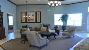 A spacious living room with a large sofa set, a coffee table, and two armchairs. There are framed pictures on the wall, a chandelier, and a large window providing natural light. - Shv1168ha - 4 Bedroom Townhome In Coral Cay Resort, Sleeps Up To 10, Just 6 Miles To Disney (Kissimmee)