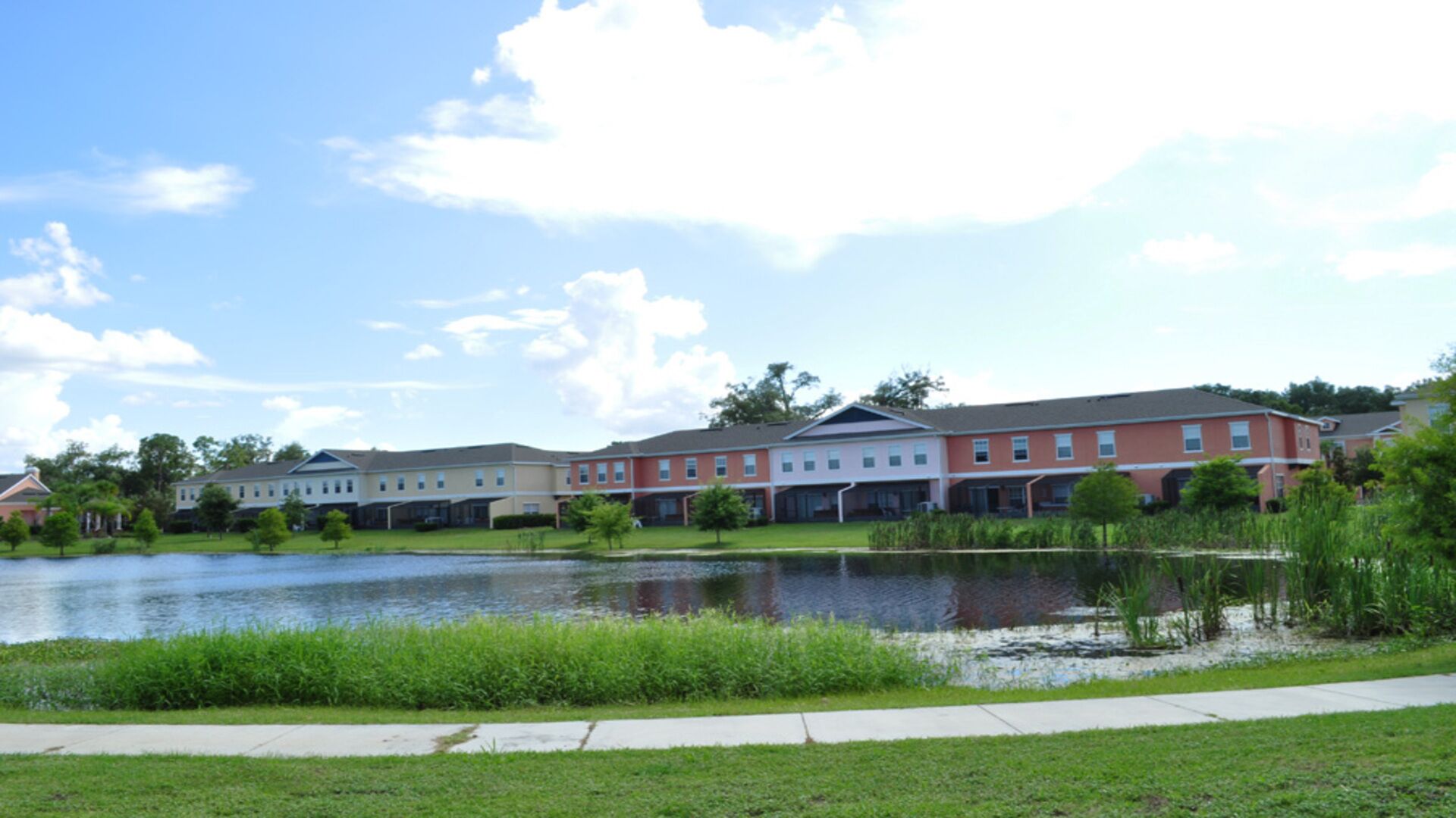 A row of townhouses with a pond in the foreground.