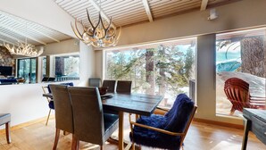 A modern dining area with a large table, chairs, and a chandelier. - Mammoth West 137 Updated Deluxe Condo, Just A Short Walk to Canyon Lodge by RedAwning (Mammoth Lakes)