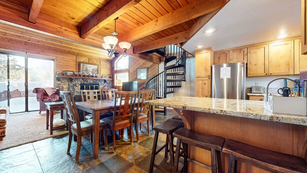 A spacious kitchen with wooden cabinets, a granite countertop, and a built-in stove. - Snowflower 26 Remodeled Spacious Condo With Great Complex Amenities by RedAwning (Mammoth Lakes)