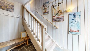 A staircase with a wooden handrail and a wooden bench at the bottom. - Mammoth West 115 Updated Condo, Just A Short Walk To Canyon Lodge by RedAwning (Mammoth Lakes)