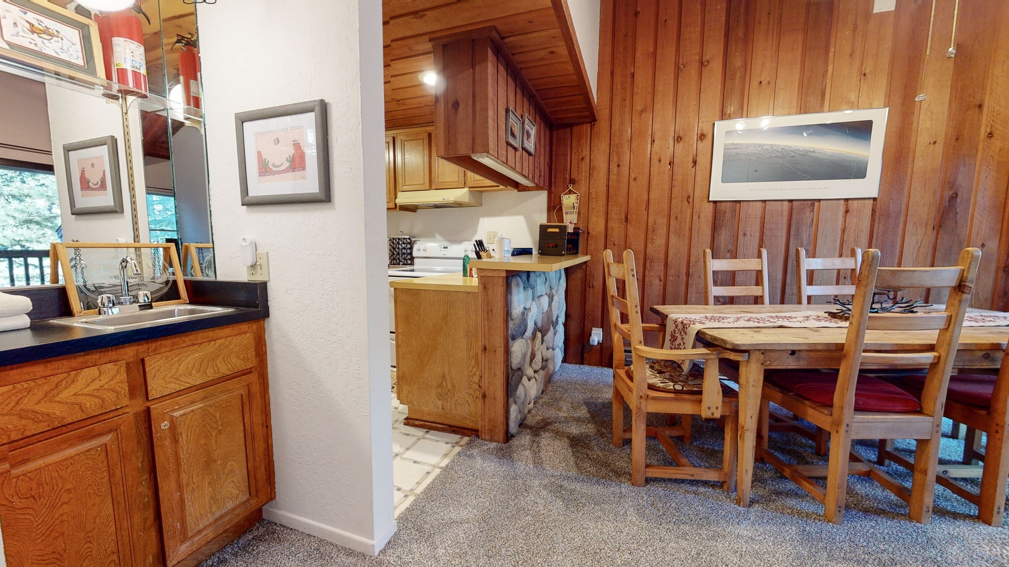 Un interior de madera con cocina, mesa y sillas.