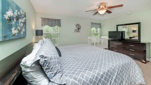 A bedroom with a bed, dresser, ceiling fan, and artwork on the walls. - Paradise Palms #2 - 6 Bed 5 Baths Villa (Kissimmee)