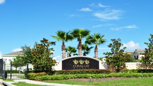 A sign for Coral Cay Resort surrounded by palm trees and greenery. - Shv1173ha - 4 Bedroom Townhome In Coral Cay Resort, Sleeps Up To 10, Just 6 Miles To Disney (Kissimmee)