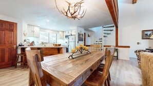 A spacious kitchen with a wooden island, white cabinets, and a chandelier. - Mammoth Sierra Townhome (Mammoth Lakes)