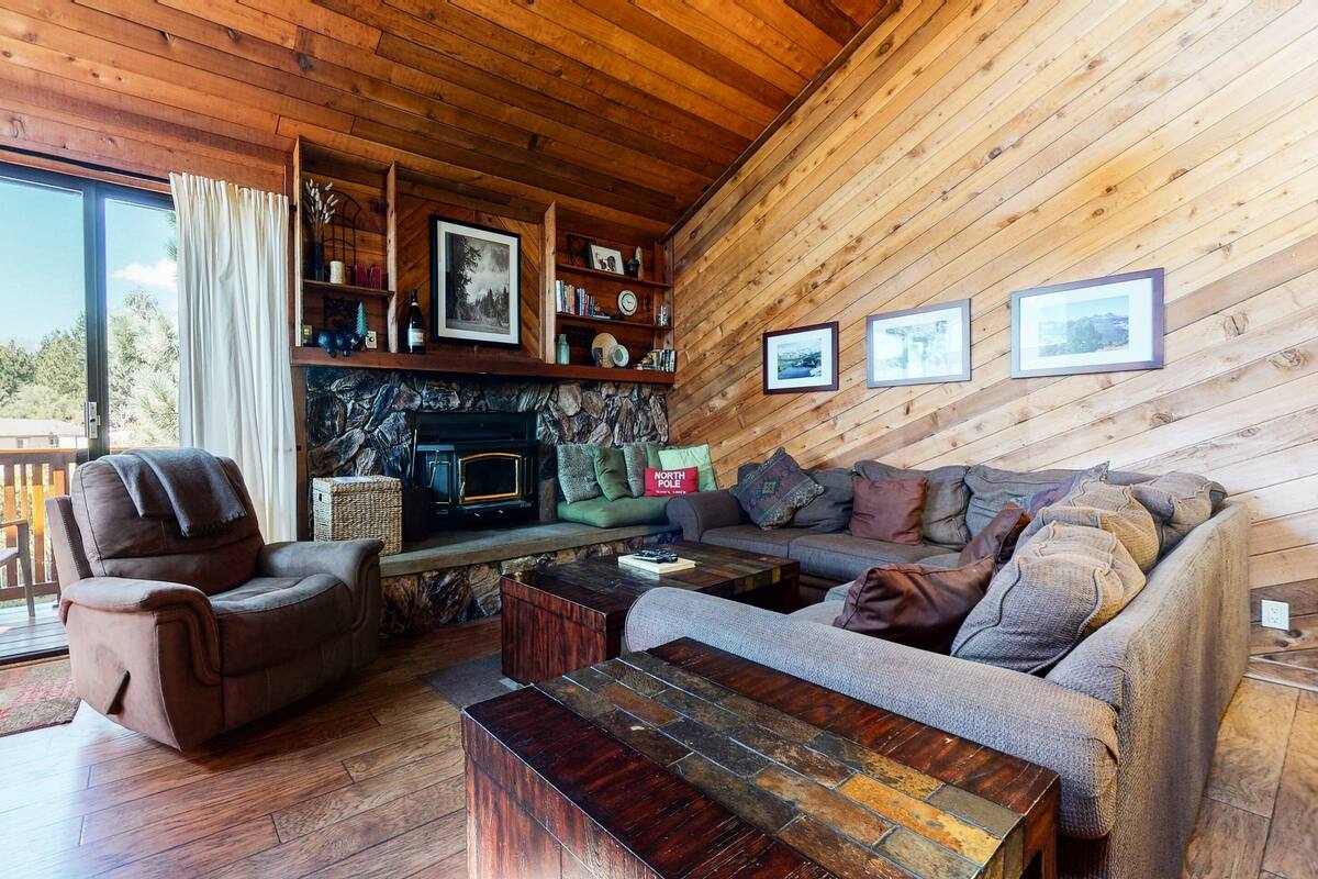 A cozy living room with a fireplace, a sofa, a chair, and a coffee table.