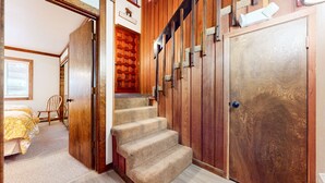 A wooden staircase leading to a room with a bed and a chair. - Mammoth West 111 Cozy Condo, Just A Short Walk to Canyon Lodge by RedAwning (Mammoth Lakes)