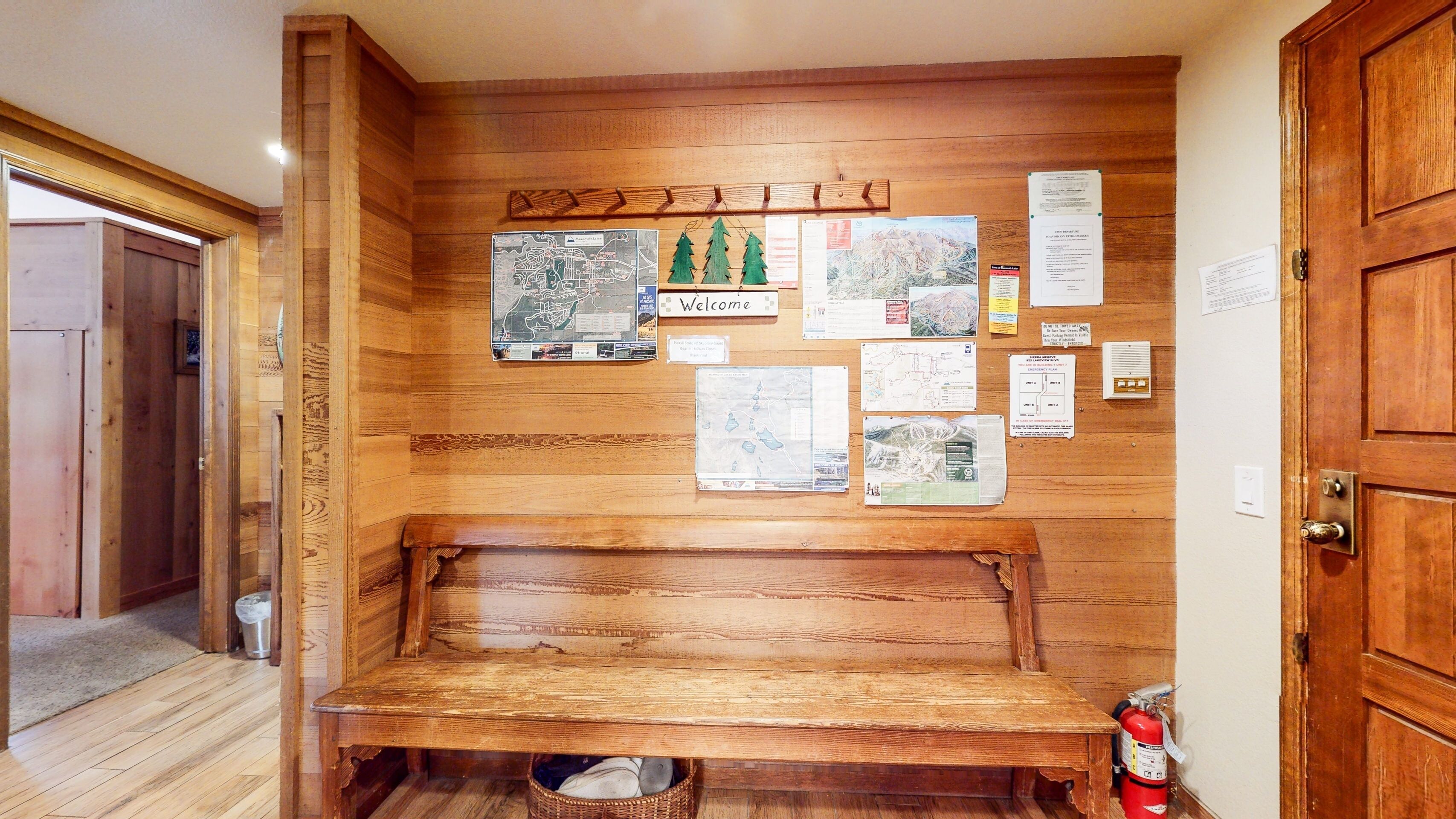 A wooden bench with a map and informational posters on the wall.