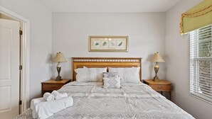 A neatly made bed with a patterned bedspread, two bedside lamps, and a framed botanical print on the wall. - Shv1170ha - 4 Bedroom Townhome In Coral Cay Resort, Sleeps Up To 8, Just 6 Miles To Disney (Kissimmee)