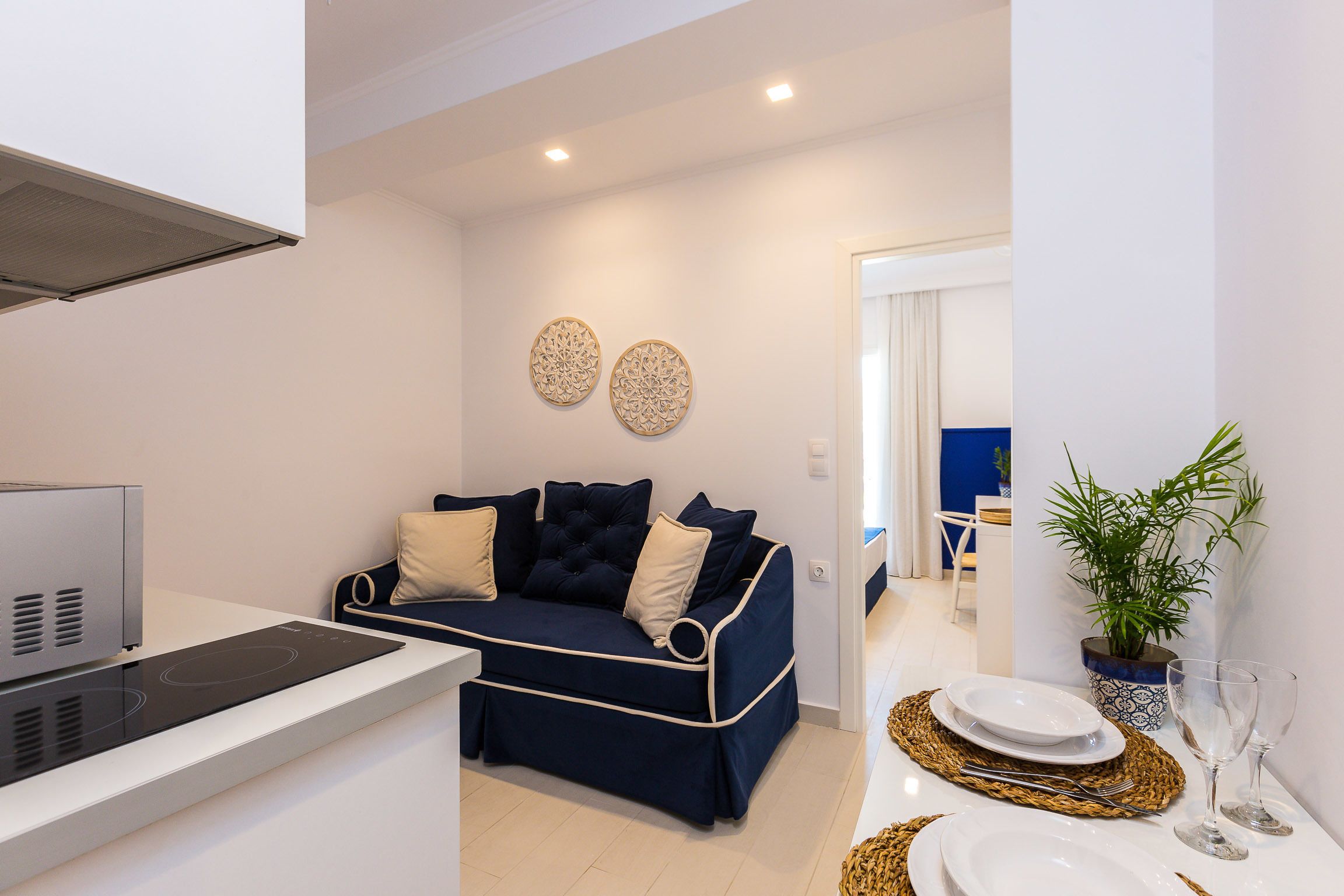 Una sala de estar moderna con un sofá, una cocina integrada y un comedor.