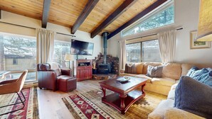 A cozy living room with a fireplace, leather furniture, and large windows. - Chateau de Montagne 17 Spacious Family Townhome with Great Complex Amenities On Shuttle Route by RedAwning (Mammoth Lakes)