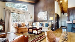 A cozy living room with a large window, a sofa set, a coffee table, and a lamp. - Chateau de Montagne 17 Spacious Family Townhome with Great Complex Amenities On Shuttle Route by RedAwning (Mammoth Lakes)