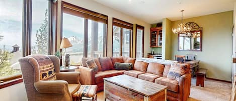 A cozy living room with a sectional sofa, a wooden coffee table, and a chair with patterned cushions.