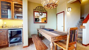 Un coin repas avec une table en bois, un banc et un miroir décoratif.