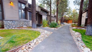 A residential property with a paved driveway, stone-lined borders, and a stone wall. - St. Moritz 12 Bright and cozy Mountain Cabin, Centrally Located by RedAwning (Mammoth Lakes)