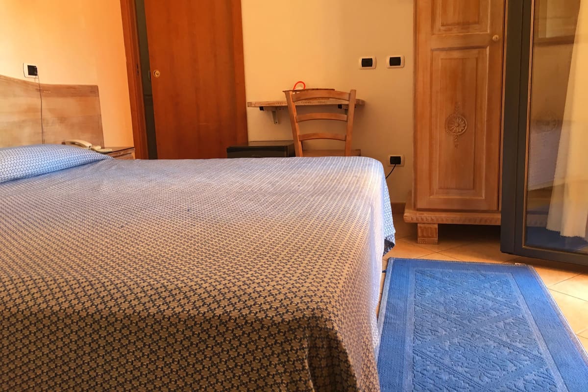 Une chambre à coucher avec un lit, un bureau et une armoire.