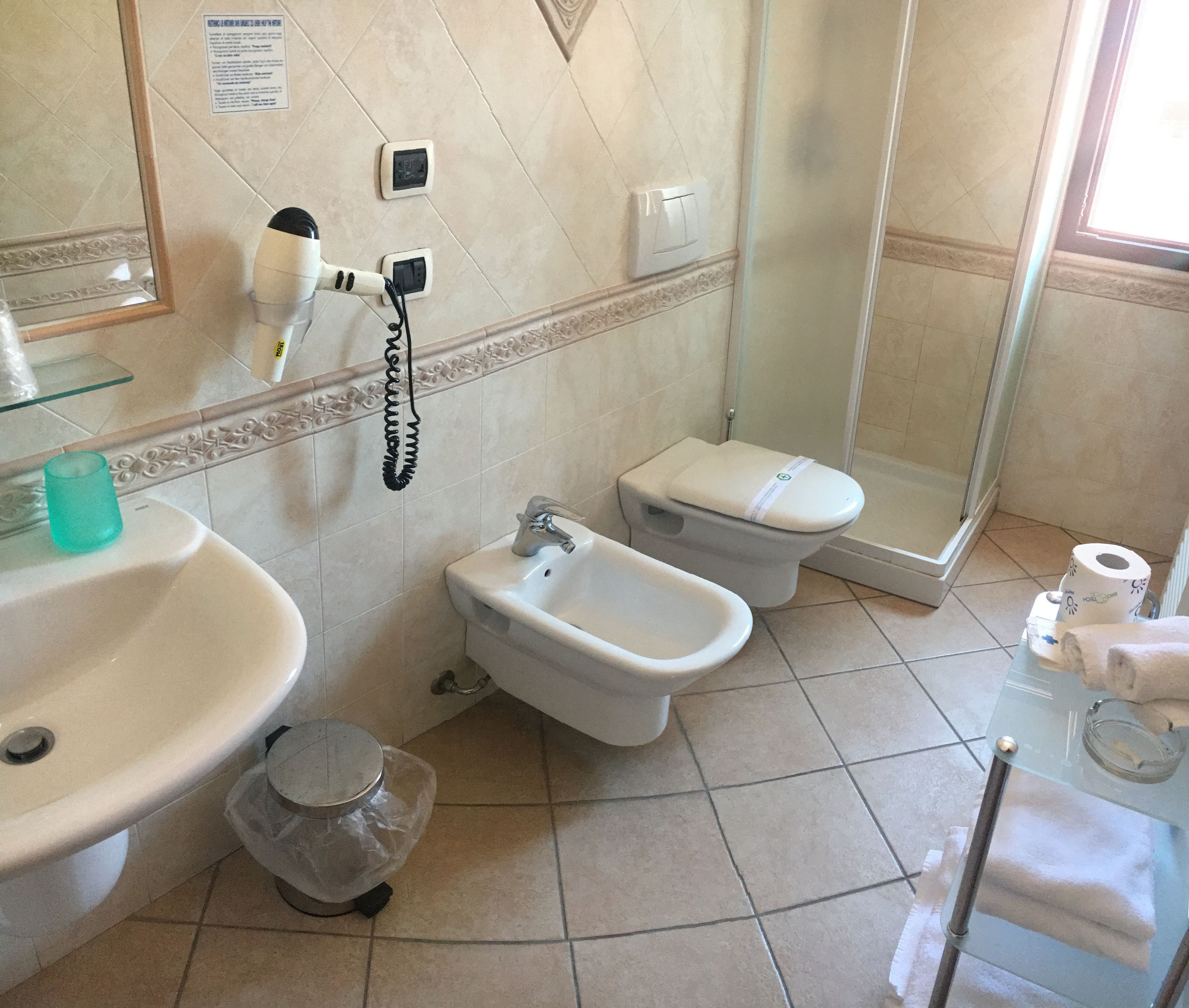 Une salle de bain équipée d’un lavabo, d’un bidet, de toilettes et d’une douche à parois en verre.