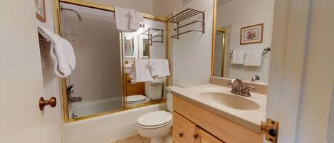 Un baño con bañera, inodoro y lavabo.