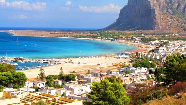 A coastal town with a beach, boats, and a prominent mountain. - Hotel La Meridiana (San Vito Lo Capo)