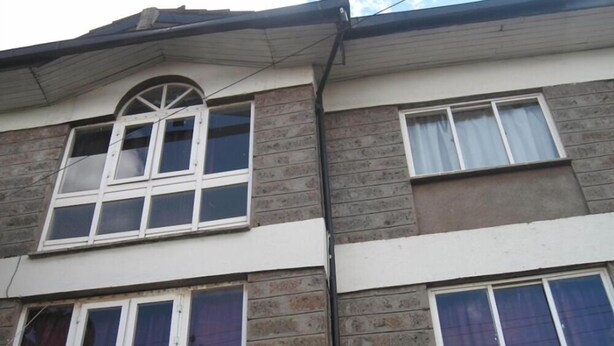 A multi-story building with a brick facade, multiple windows, and a flat roof. - Velvet House (Nairobi)