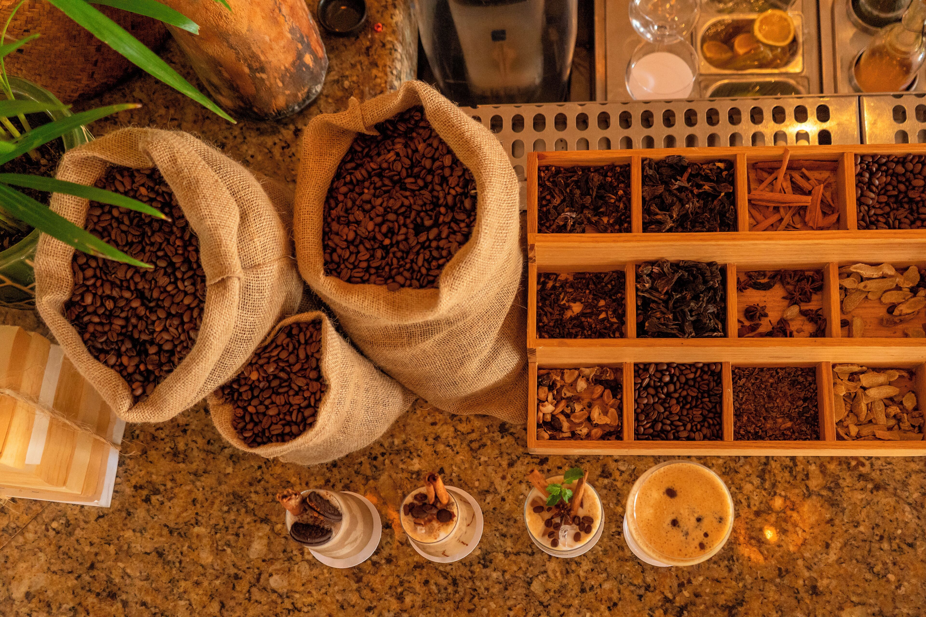 Eine Küchenarbeitsplatte mit Kaffeebohnen, Gewürzen und einer Kaffeemaschine.