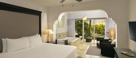 Ein Hotelzimmer mit einem großen Bett, einem Deckenventilator, einem Fernseher, einem Essbereich mit Tisch und Stühlen sowie Blick ins Freie.