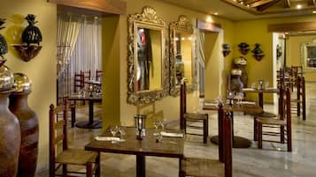 A dining area with ornate mirrors, wooden furniture, and a polished floor.