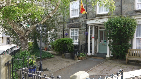 Un edificio de piedra con un letrero que dice "Ivy House" y una bandera.