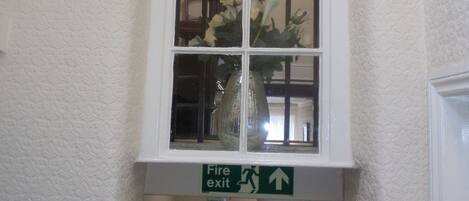 Una ventana con un letrero de salida de incendios debajo.