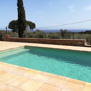 Una piscina al aire libre, sillones reclinables de piscina