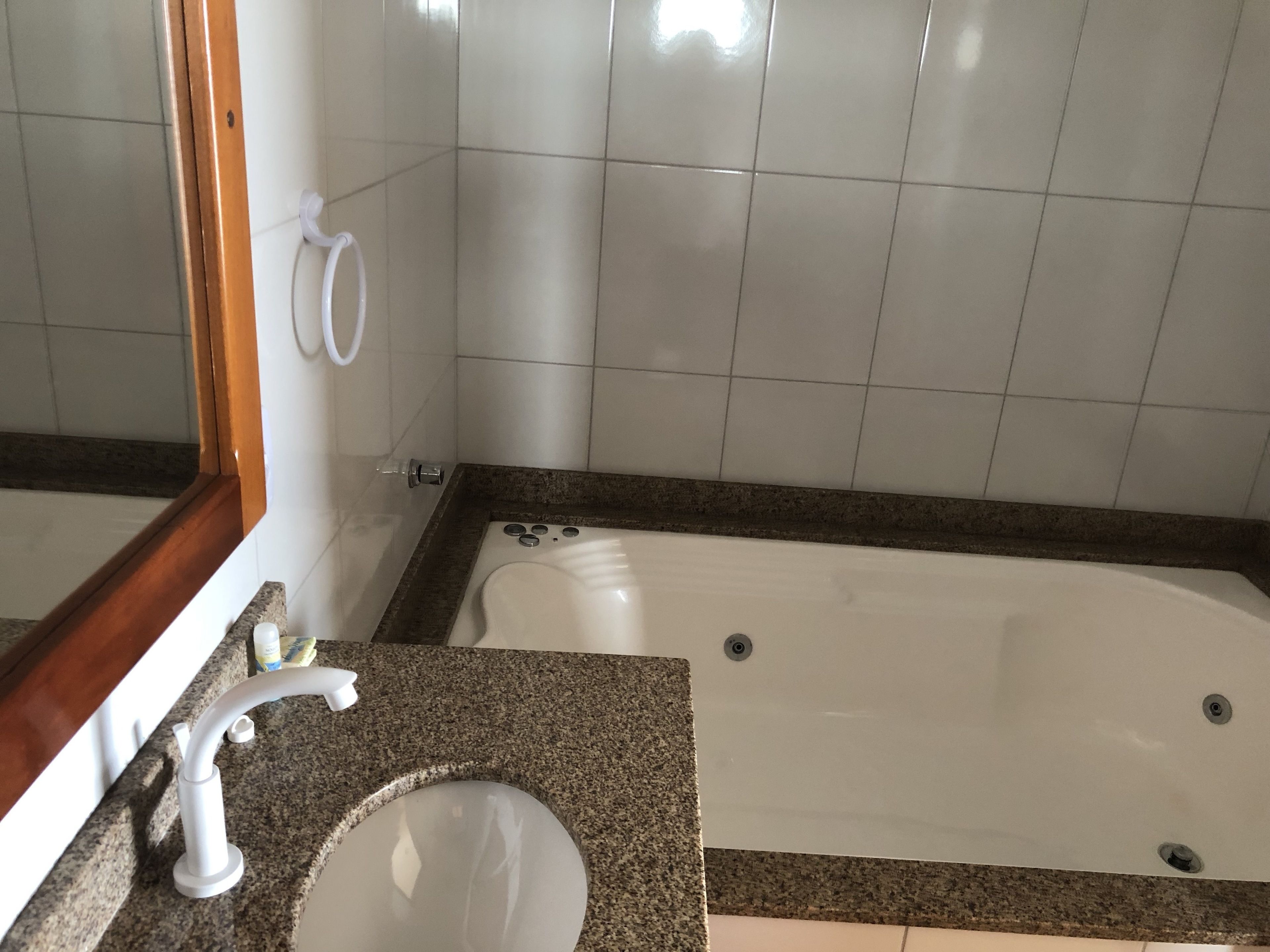 Un baño con lavamanos, espejo y bañera.